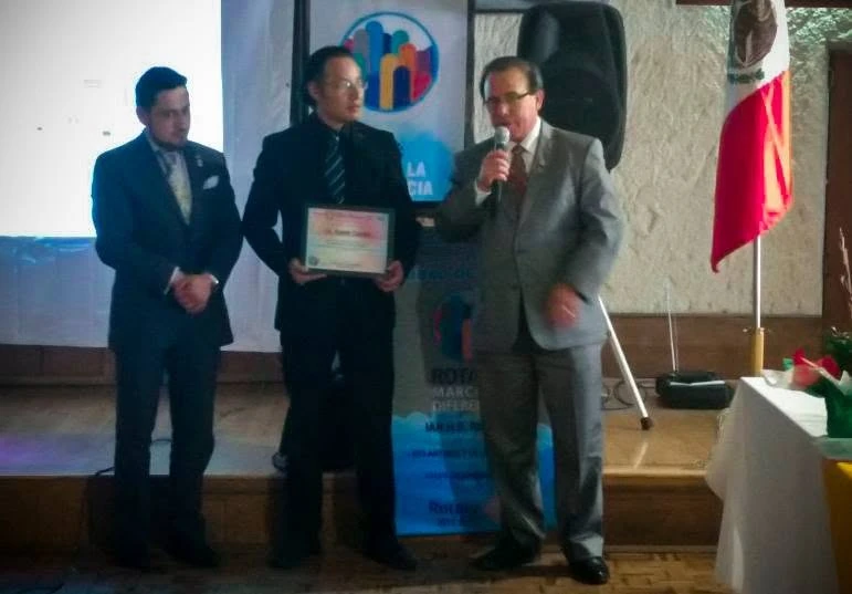 Daniel Canales recibiendo un reconocimiento en un escenario